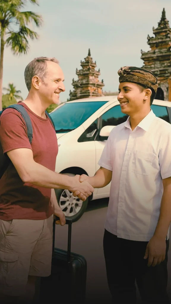 Professional Bali airport transfer driver greeting international guests at night, with multilingual signage and warm welcome.