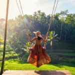 Sunrise light beams filtering through palm trees over Tegalalang Rice Terrace Ubud Bali