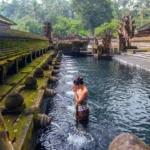 Traditional Balinese stone shrines and sacred spring pool at Tirta Empul Temple in Tampaksiring Bali