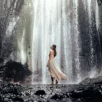 Tukad Cepung Waterfall in Bali with sunlight beams shining into the cave canyon