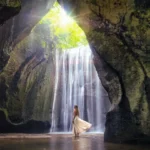 Wide angle view of Tukad Cepung Waterfall cascading into the natural cave pool Bali