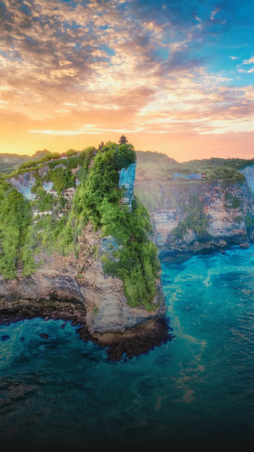 Tirta Empul Temple 27 Uluwatu Temple perched on a dramatic cliff above the Indian Ocean, with golden sunset light and Kecak dancers preparing nearby