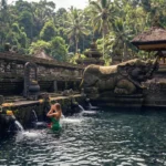 Peaceful reflection pool and historic pavilion inside Tirta Empul Temple grounds Bali
