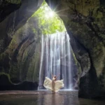 Scenic cave waterfall at Tukad Cepung surrounded by mossy cliff walls in Bali