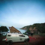 BALI CAMPERVAN, Camping with campervan in Bali featuring van parked at scenic highland site with sunrise glow, forest surroundings, and cozy outdoor setup — perfect for nature lovers and flexible travel enthusiasts.