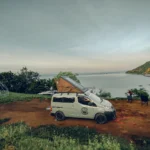 CAMPERVAN - EN - Home 18 Campervan East Bali diparkir di tengah lanskap hijau Karangasem dengan gunung di kejauhan