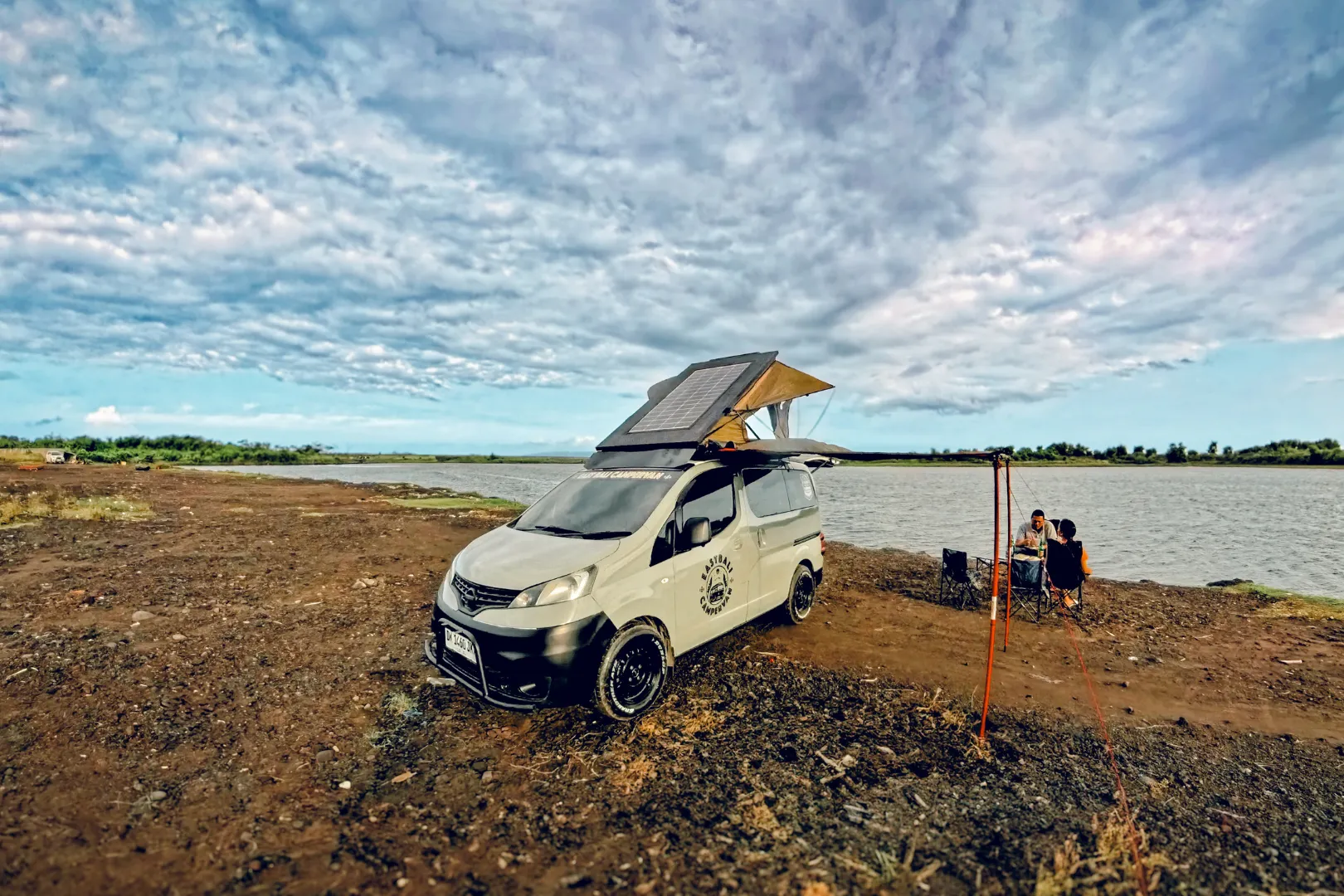 Campervan car parked near a scenic Bali coastline, ready for a road trip adventure.
