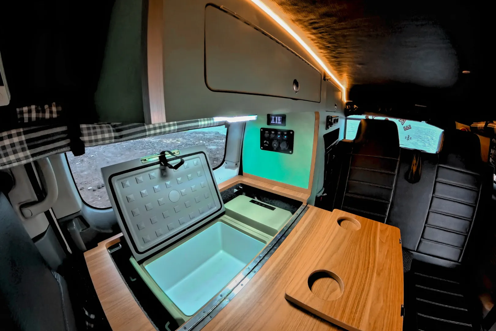 Campervan car parked under palm trees with ocean view in Bali.