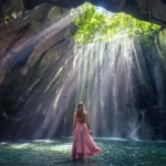Cascada Tukad Cepung en Bali con luz solar iluminando las paredes del cañón de roca