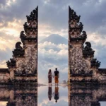 Intricately carved stone Naga dragon staircase descending through Lempuyang Temple with morning mist over Karangasem valley.