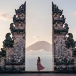 Traditional Balinese wooden shrines, split gates, and dragon carvings at Pura Lempuyang with mountain views.